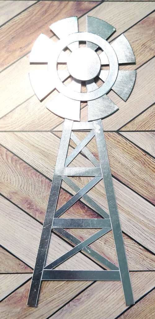 A windmill embellishment made from metallic paper using basic shapes.