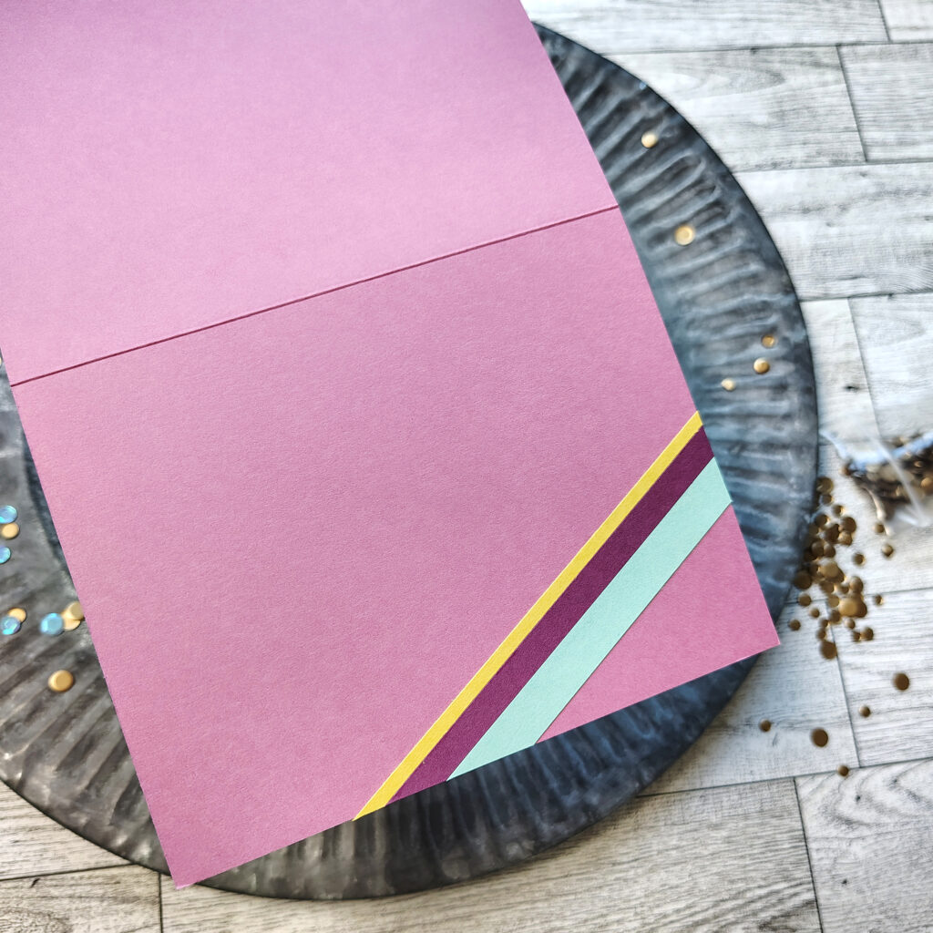 The insdie of a greeting card decorated with stripes of paper.